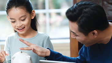Anak sedang menabung bersama ayahnya