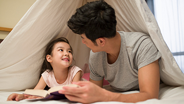 Ayah dan anak sedang membaca buku