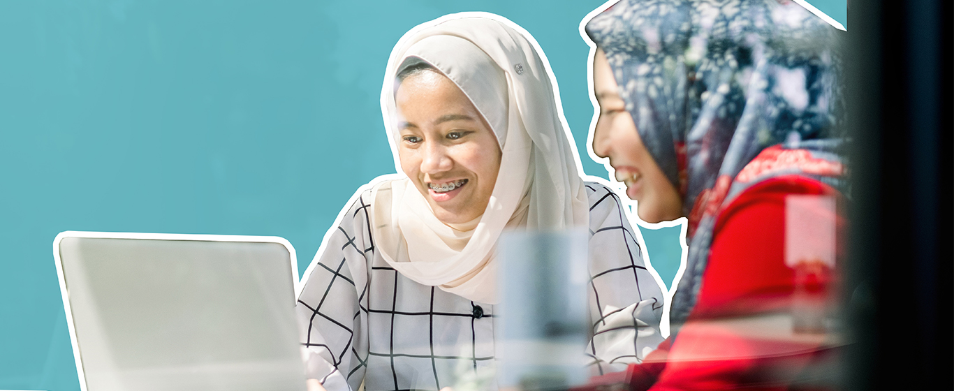 dua wanita sedang melihat laptop