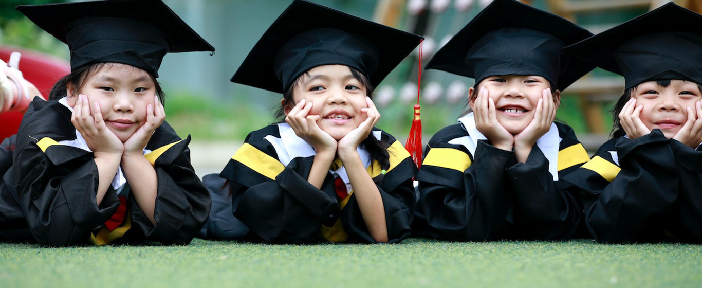 4 anak kecil memakai toga