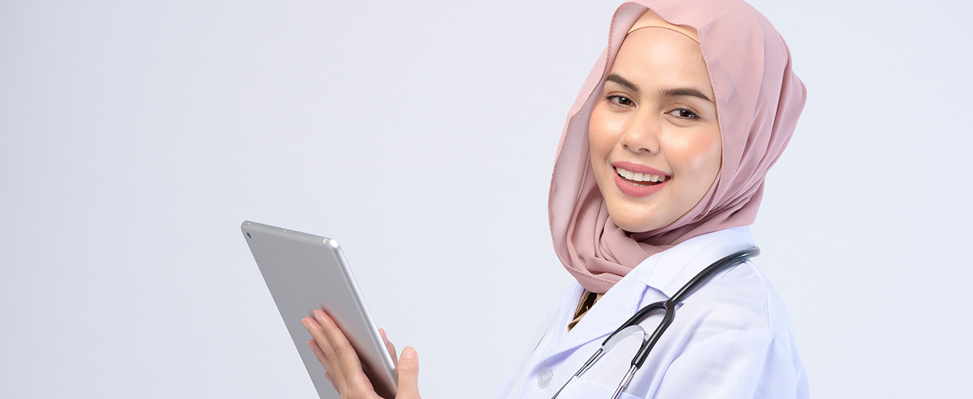dokter wanita muslim tersenyum memegang tablet