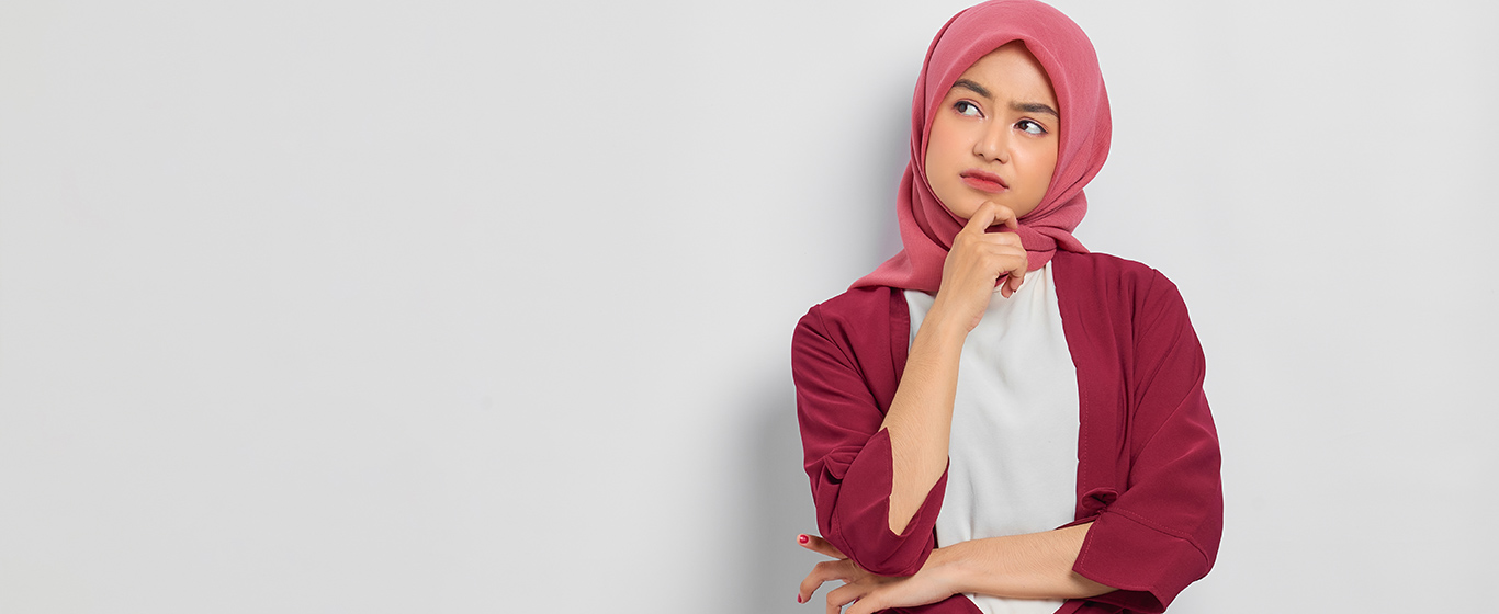 wanita berjilbab merah sedang berpikir