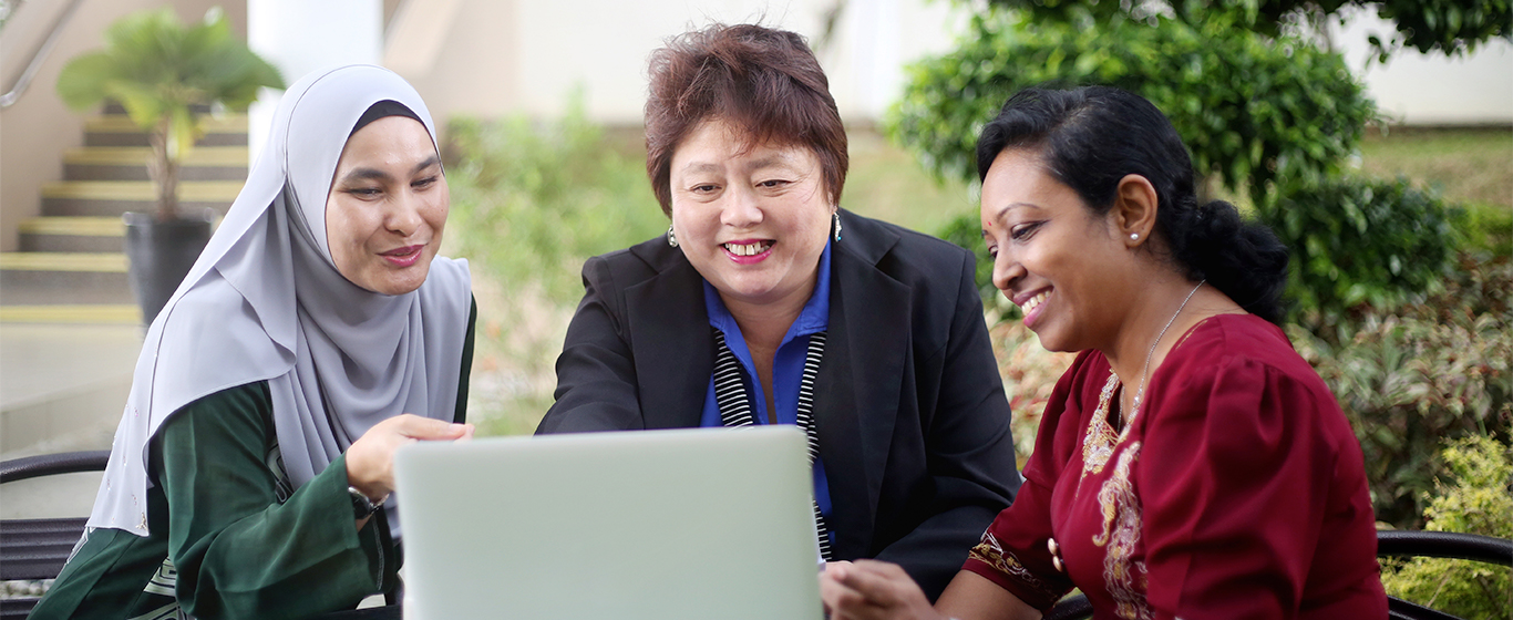 Tiga wanita sedang melihat laptop