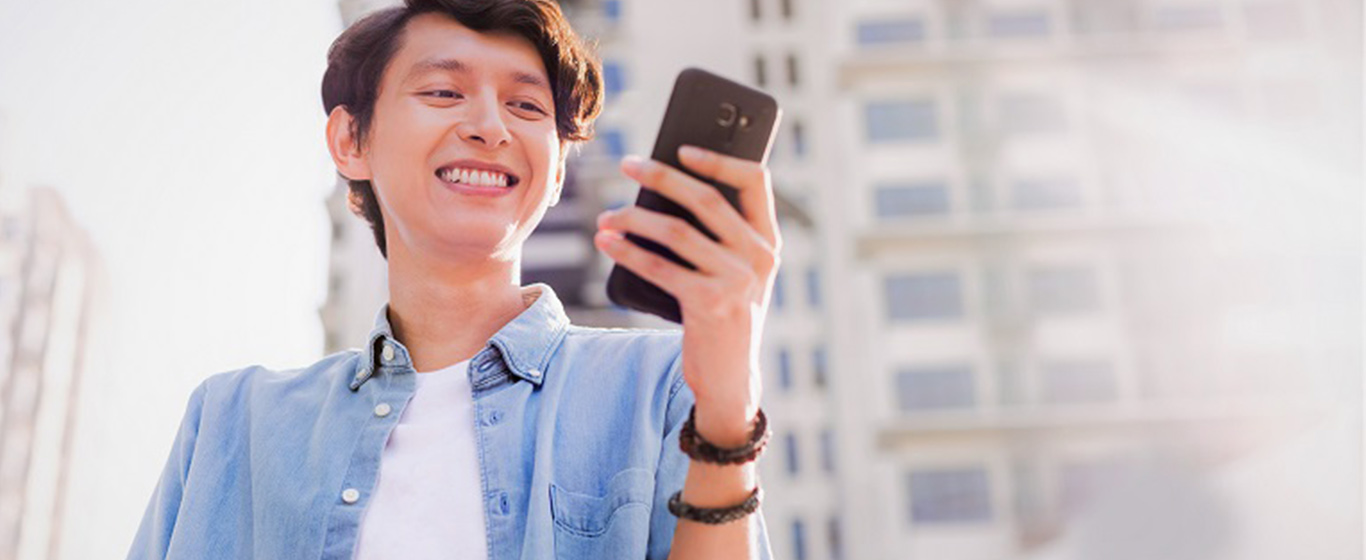 Pria tersenyum melihat handphone