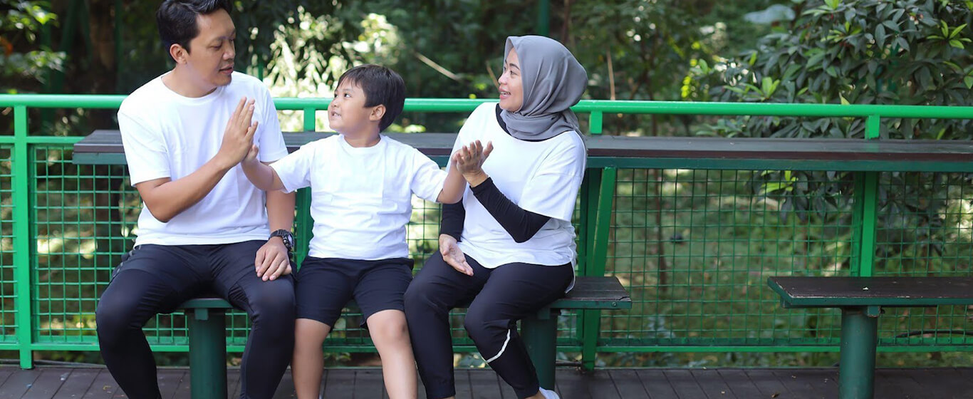 Keluarga sedang duduk di bangku taman