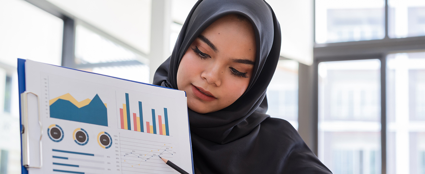 Wanita berjilbab hitam presentasi grafik sistem