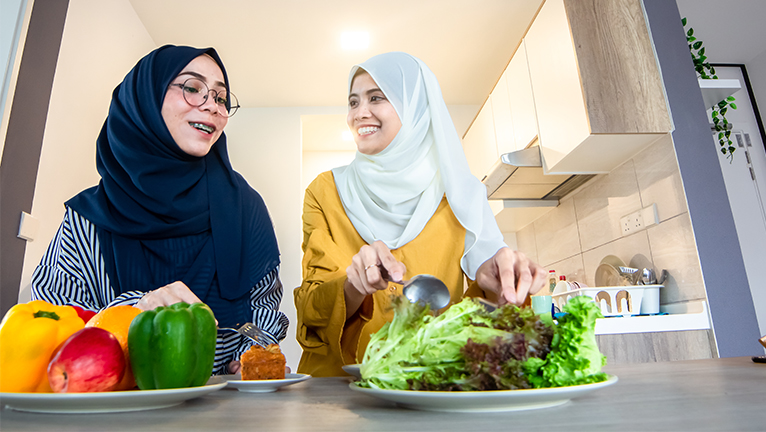 Dua wanita sedang menyiapkan makanan sehat