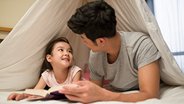 Ayah sedang membaca buku bersama anaknya